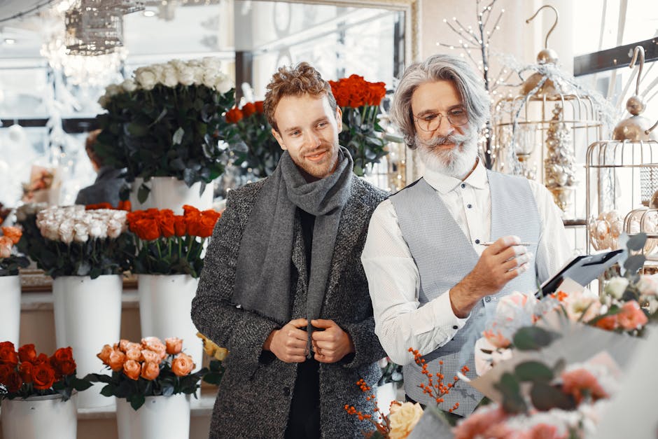 A flower shop interior with an array of fresh floral arrangements, including vibrant red, pink, and white blooms displayed in tall white vases and smaller containers. The flowers—such as roses, peon
